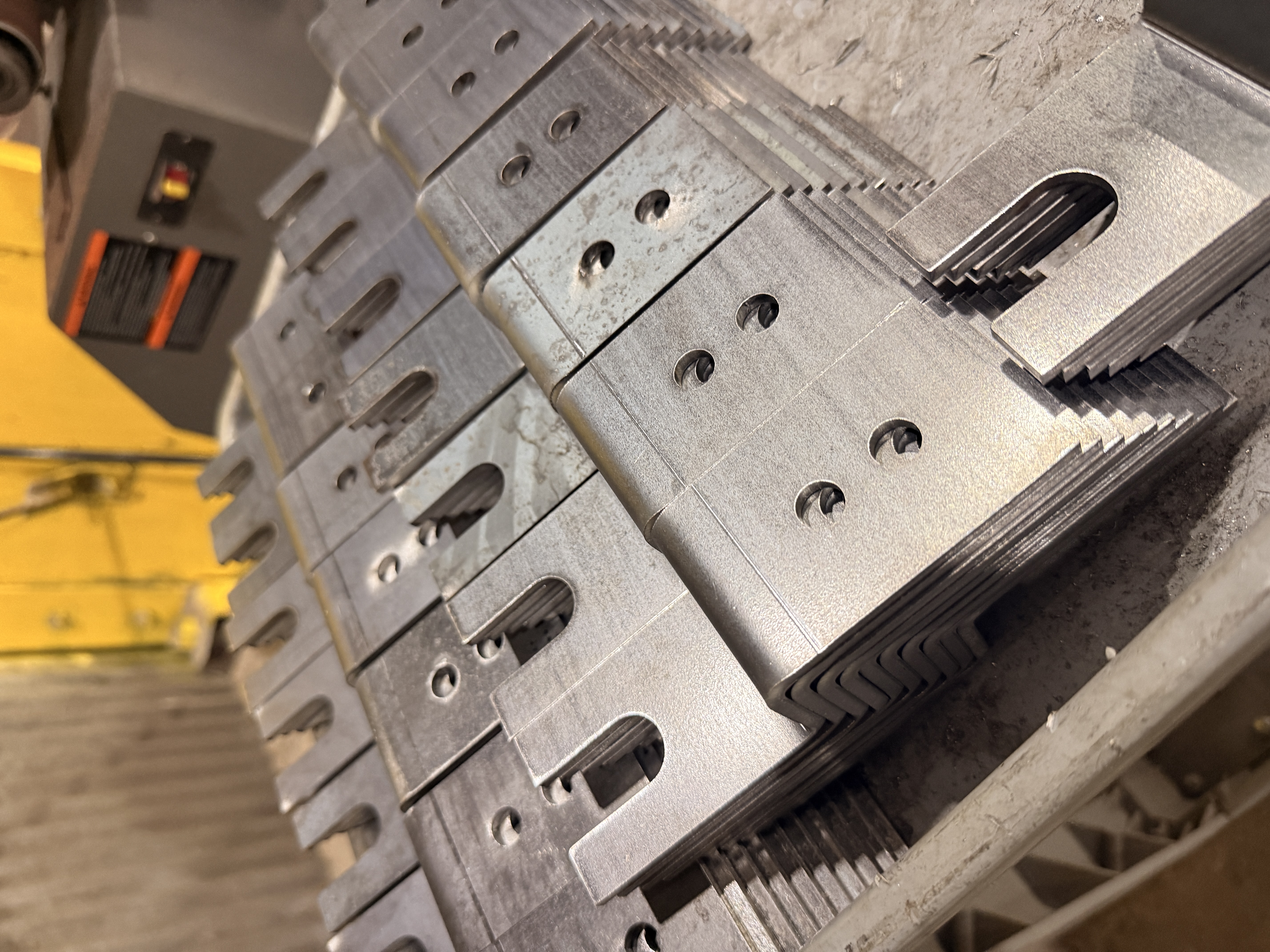 Stacks of formed metal brackets with slots and holes